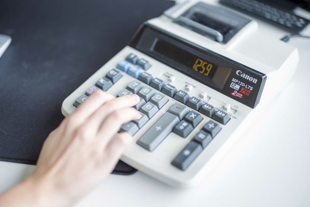 imagebild hand auf kalkulator wie er in einer steuerberatungs und buchhaltungskanzlei taeglich zum einsatz kommt